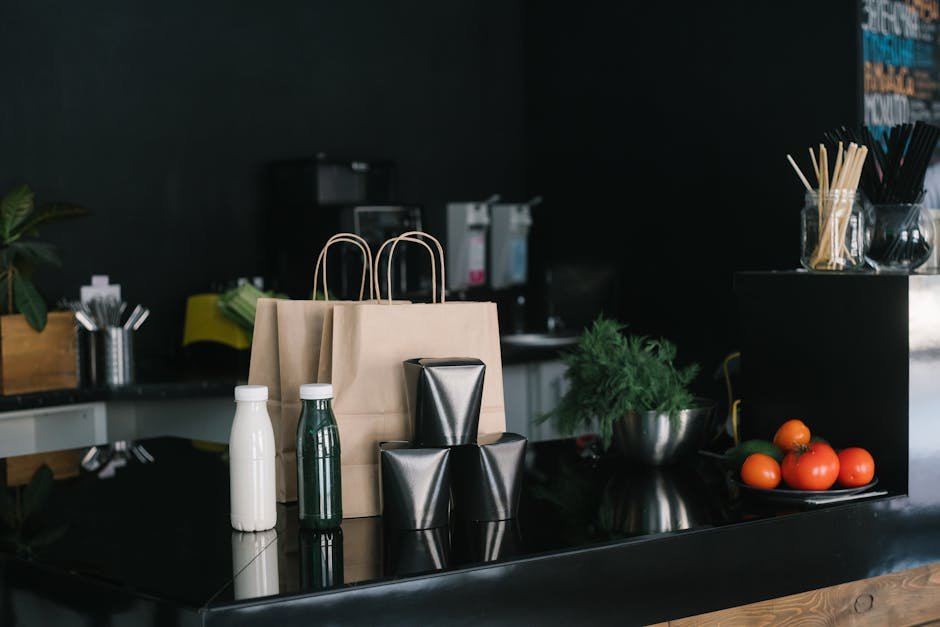 Eco-friendly takeaway packaging in a modern kitchen setting with fresh ingredients and cutlery.